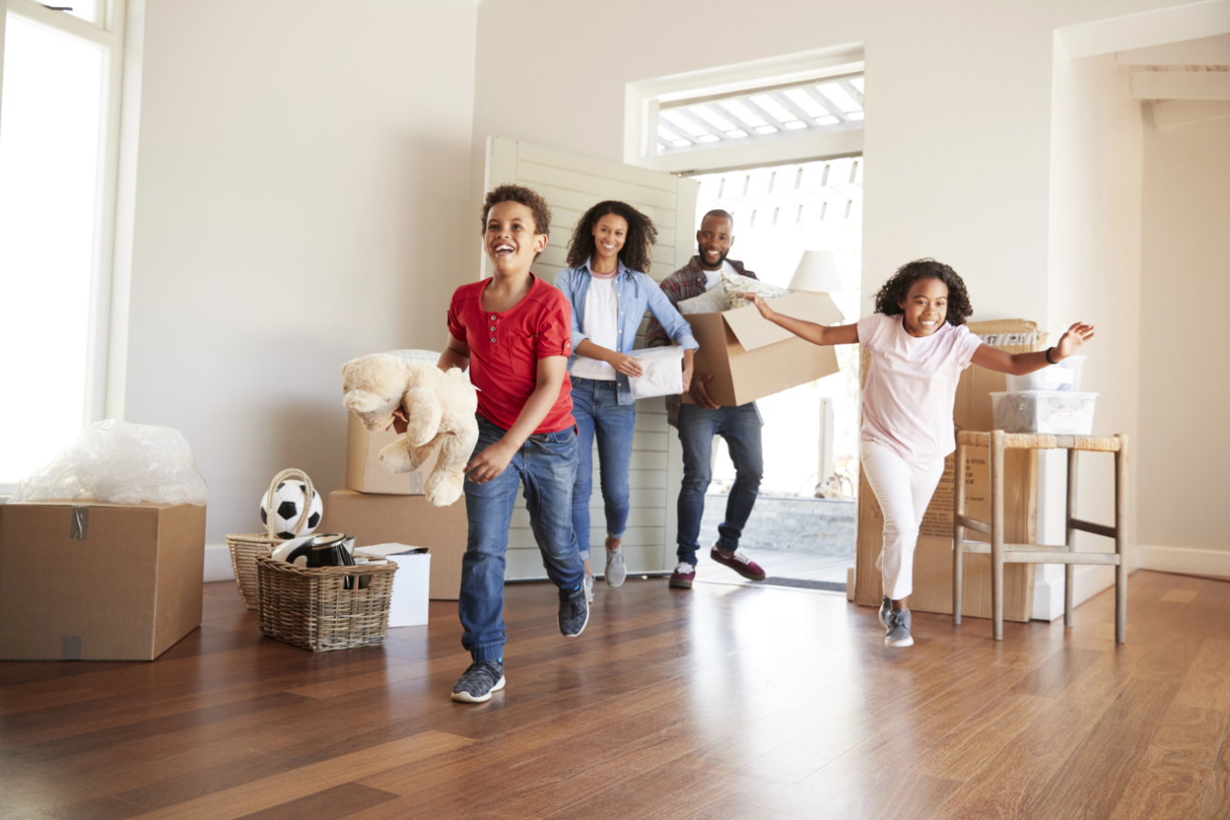 Excited Family Carrying Boxes Into New Home On Moving Day